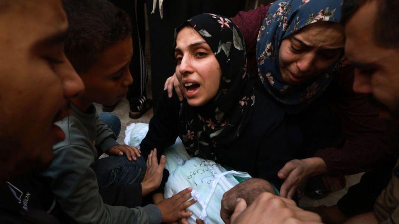 Seorang perempuan menangis histeris sambil menggendong jenazah bayi perempuannya yang tewas dalam serangan Israel di Rafah, Jalur Gaza bagian selatan, pada 1 Desember 2023. (AFP)
