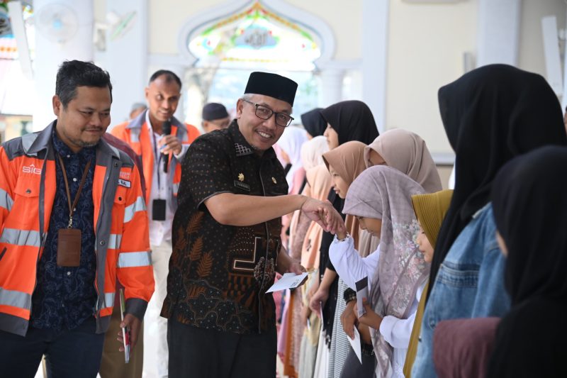 Asisten I Sekda Aceh Besar Farhan AP, di dampingi General Affairs (GA) dan Community Relations (Comrel) Manager PT SBA Tafaul Rijal, menyerahkan santunan anak yatim, di Masjid Al-Istiqamah, Kemukiman Kueh, Kecamatan Lhoknga, Kabupaten Aceh Besar, Kamis (20/03/2025). 