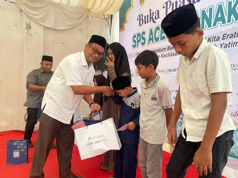 Plt Kadis Kominfo Aceh Besar Khairul Huda SKom MM, menyerahkan santuan kepada anak yatim dalam acara yang digelar SPS Aceh, di Gampong Doy, Kecamatan Ulee Kareng, Kota Banda Aceh, Kamis (20/03/2025) sore.