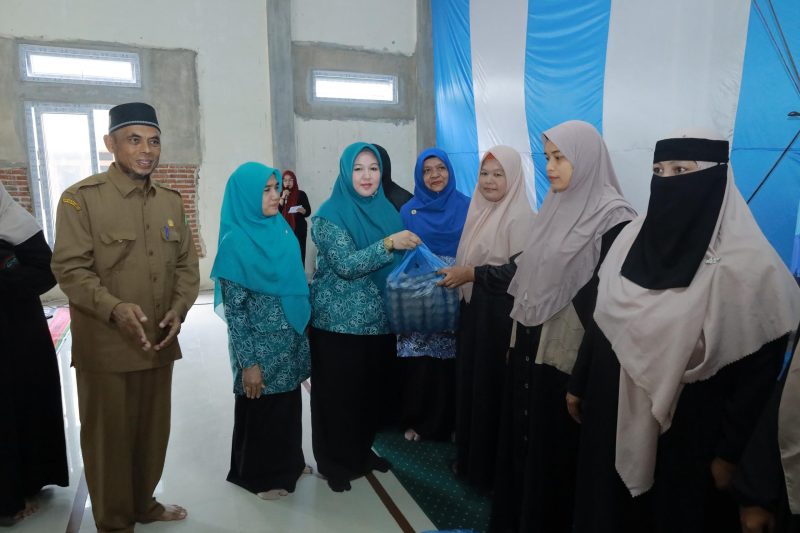 Ketua TP PKK Aceh Besar Hj Rita Mayasari menyerahkan bantuan kepada seorang masyarakat yang tergolong dalam keluarga rentan, pada pembukaan Sekolah Lansia Ranub Seulaseh, di Meunasah Gampong Meunasah Karieng, Kemukiman Lamlhom, Kecamatan Lhoknga, Kabupaten Aceh Besar, Senin (28/04/2025). 