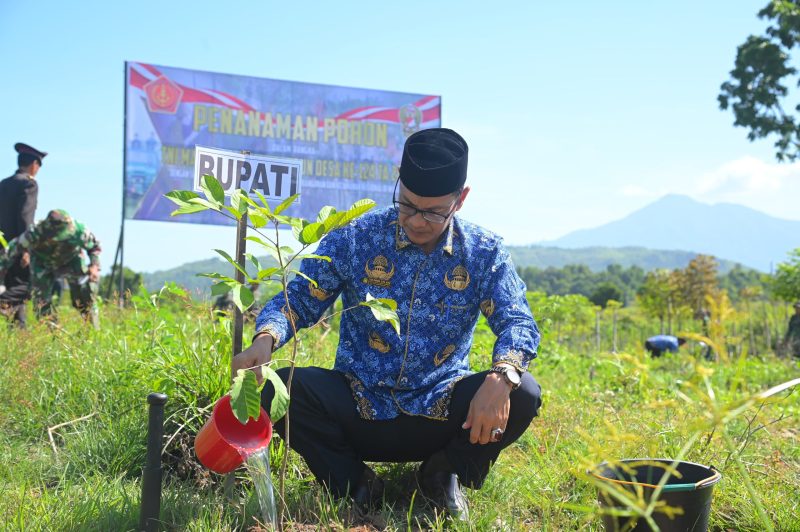 Bupati Aceh Besar yang diwakili Staf Ahli Bidang Keistimewaan Aceh SDM dan Kerjasama, Adi Dharma SPd MPd menanam pohon rambutan pada kegiatan TMMD di Gampong Weu, Kota Jantho, Senin (02/06/2025).