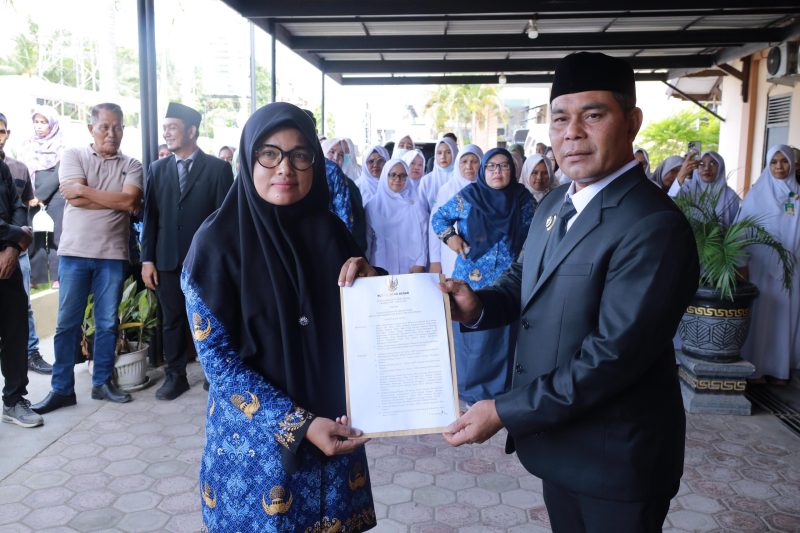 Bupati Aceh Besar Muharram Idris menyerahkan SK kepada Nelly Ulfiati SKM MPH sebagai Pelaksanaan Tugas (Plt) Kepala Dinas Kesehatan Kabupaten Aceh Besar usai melantik melantik dr. Bunaiya Putra MKM sebagai Direktur Rumah Sakit Umum Daerah (RSUD) Aceh Besar, di Teras RSUD setempat, Indrapuri, Senin (02/06/2025).