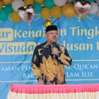 Kepala Dinas Syariat Islam Aceh Besar Rusdi S.Sos MSi menyampaikan sambutan pada Tasyakkur Kenaikan Tingkat IV dan Wisuda III TPQ Baburridha di halaman Mesjid Lam Ilie, Indrapuri, Minggu (22/06/2025). 