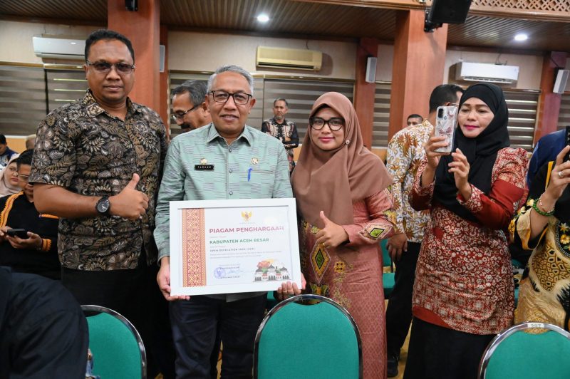 Asisten 1 Sekdakab Aceh Besar, Farhan AP menerima Piagam Penghargaan dari Asiten 2 Sekda Aceh, Dr.Ir. Zulkifli, M.Si., di Gedung Serba Guna Kantor Gubernur Aceh, Banda Aceh, Kamis (26/06/2025). 