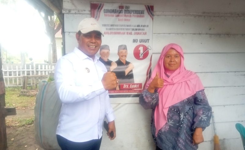 Bupati Aceh Besar, H Muharram Idris bersalam dengan simpatisannya Bu Tuti (58) saat meninjau pintu air di Cot Gue, Gampong Bung Pageu, Kecamatan Blang Bintang, Aceh Besar, Rabu (25/06/2025).