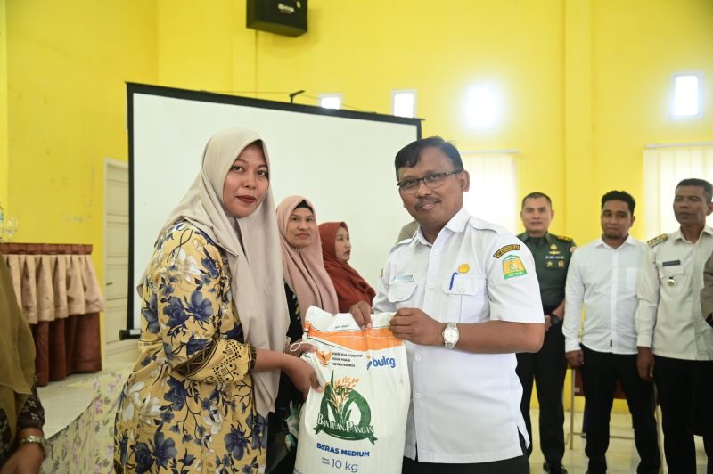 Kadis Pangan Aceh Besar Aliyadi SPi MM, menyerahkan bantuan beras BPB secara simbolis kepada seorang penerima manfaat, di Gedung UDKP Kecamatan Peukan Bada, Kabupaten Aceh Besar, Rabu (16/07/2025) pagi. 