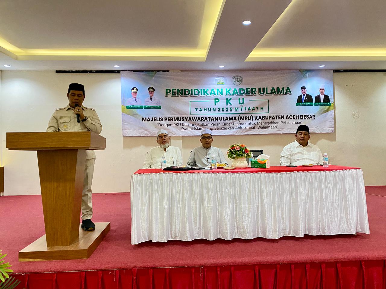 Bupati Aceh Besar, H. Muharram Idris menyampaikan sambutan sekaligus membuka Pendidikan Kader Ulama (PKU) Tahun 2025 M / 1447 H yang diselenggarakan oleh Majelis Permusyawaratan Ulama (MPU) Kabupaten Aceh Besar, di Hotel Madinatul Zahara, Kecamatan Darul Imarah, Kabupaten Aceh Besar, Senin (03/11/2025).
