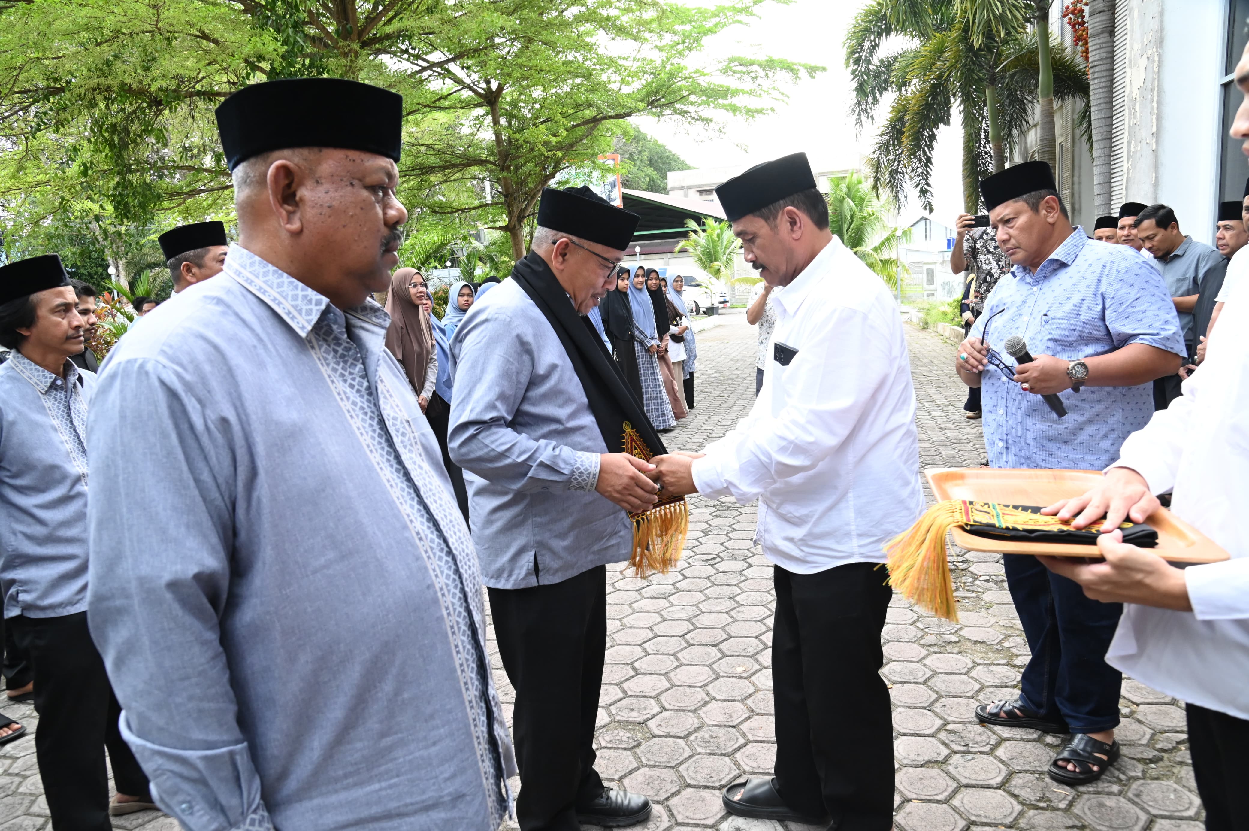 Wakil Bupati Aceh Besar Drs H Syukri A Jalil, mengalungkan sal kepada Ketua Kafilah, Farhan AP, Sekretaris kafilah Rusdi SSos MSi pada acara penyambutan Kafilah Aceh Besar saat tiba di Gedung Dekranasda, Gampong Gani, Kecamatan Ingin Jaya, Aceh Besar, Sabtu (08/11/2025).