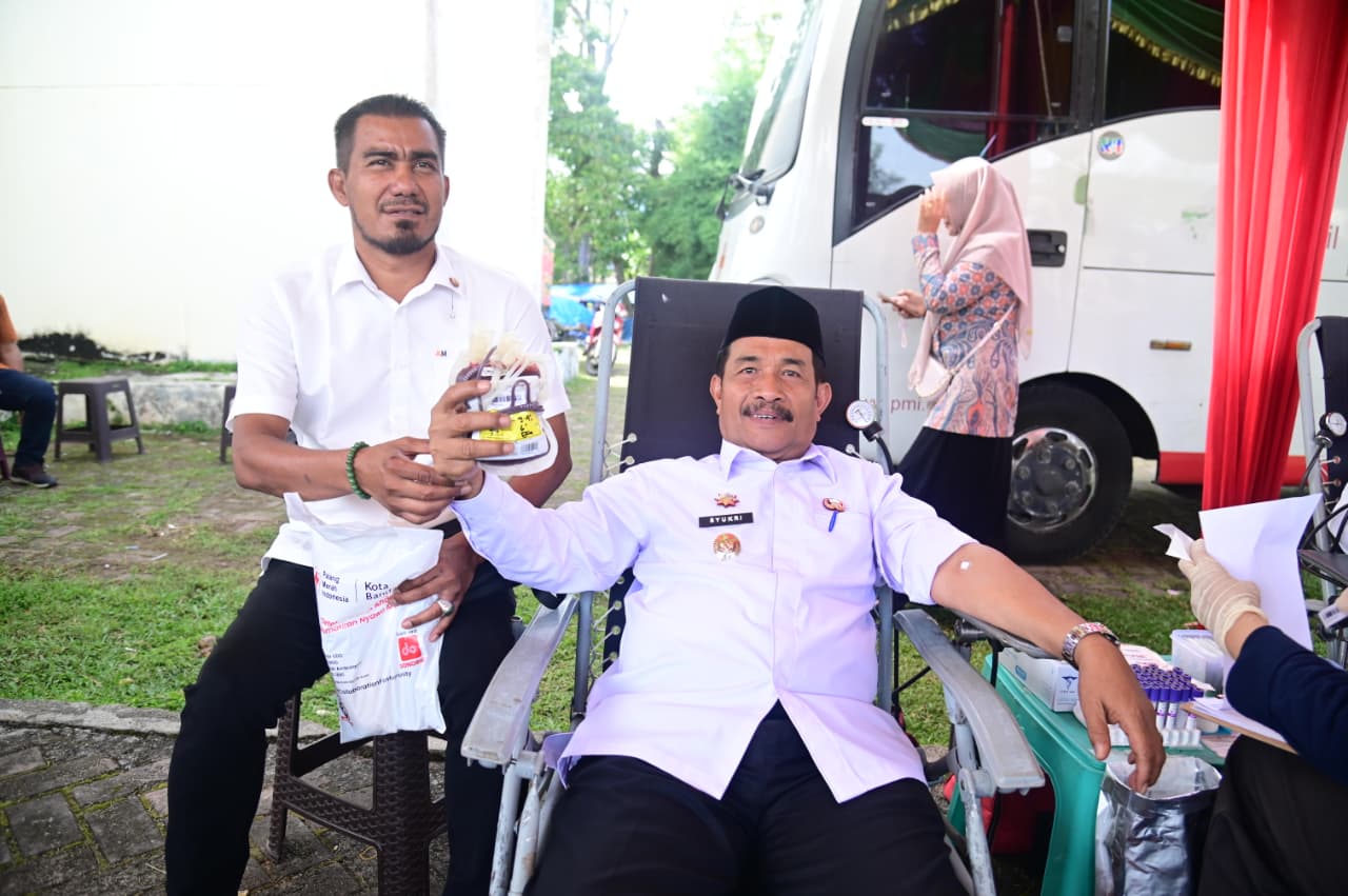 Wakil Bupati Aceh Besar Drs Syukri dan Plt Ketua PMI Aceh Besar Dr Ansari Muhammad MSi memperlihatkan kantong darah hasil donor pada peringatan Uroe Lahe Aceh Besar di Kota Jantho, Kamis (20/11/2025).