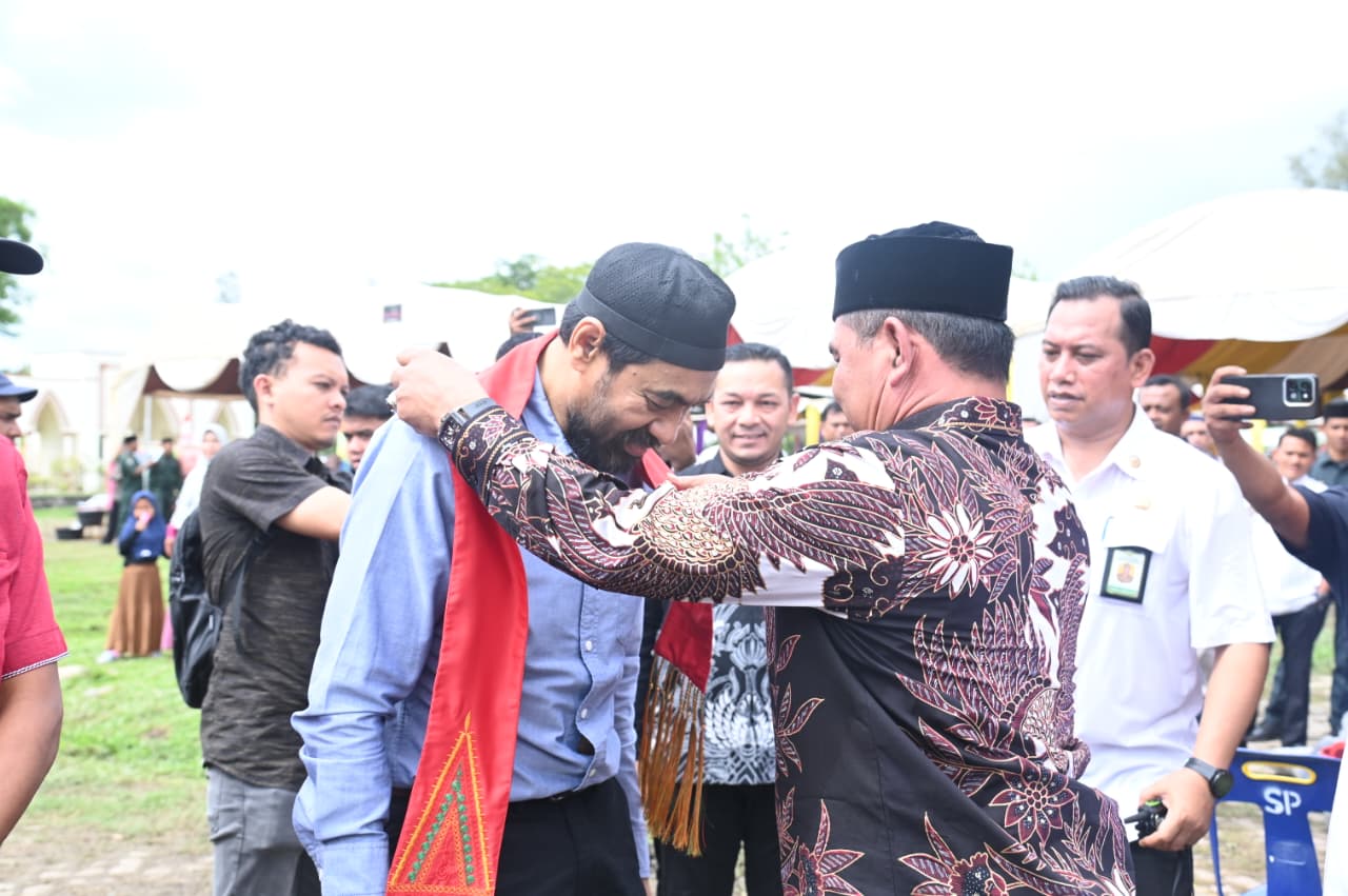 Bupati Aceh Besar Muharram Idris menyematkan selempang selamat datang kepada Gubernur Aceh Muzakkir Manaf pada Maulid Akbar Aceh Besar di Arena Pameran Pembangunan dan Expo UMKM, Lapangan Bungong Jeumpa, Kota Jantho, Kamis (20/11/2025).