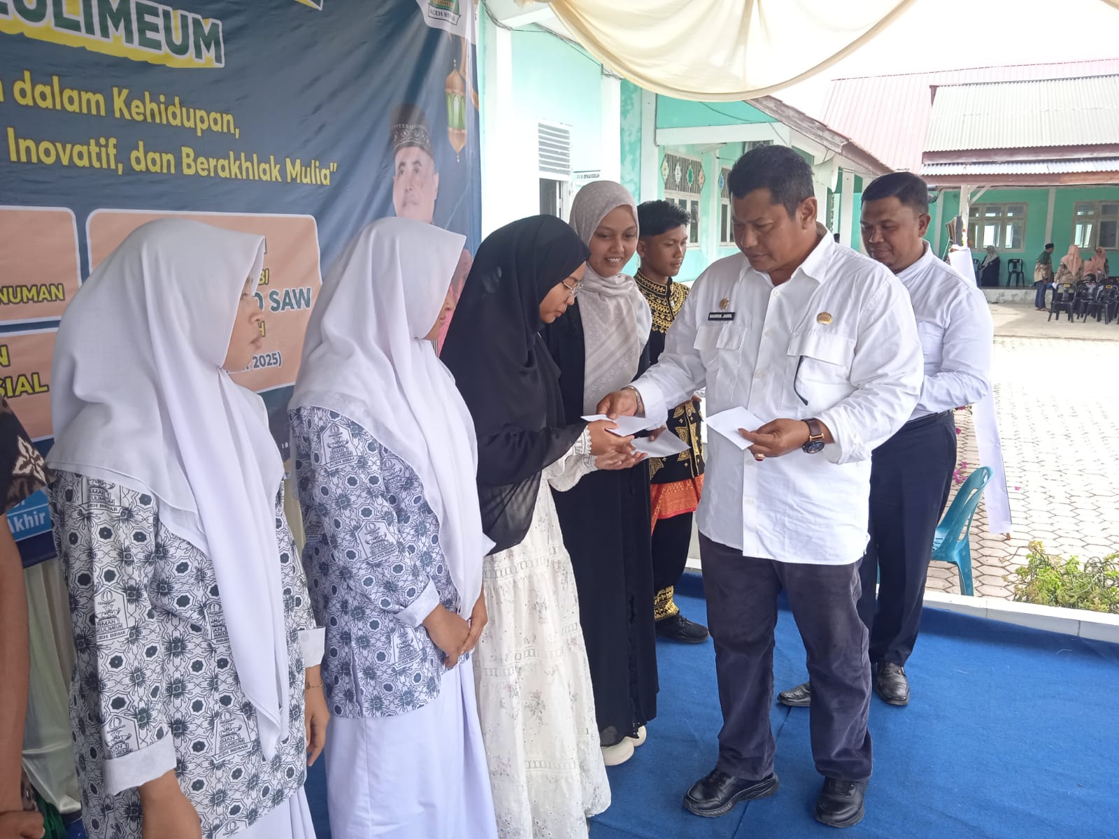 Sekdakab Aceh Besar Bahrul Jamil SSos MSi secara simbolis menyerahkan santunan sosial kepada siswa SMA 1 Seulimeum, Rabu (19/11/2025).
