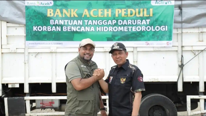 Dirut Bank Aceh Fadhil Ilyas salam berfoto bersama Bupati Pidie Jaya Sibral Malasyi di sela-sela penyerahan bantuan Bank Aceh untuk korban bencana hidrometeorologi di Posko Utama Penanganan Banjir Pidie Jaya,Meureudu, Sabtu (13/12/2025).
