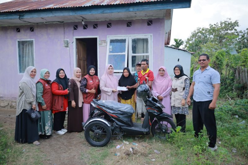 TP-PKK Aceh Besar, Hj. Rita Mayasari menyerahkan bantuan alat bantu fisik berupa satu unit sepeda motor roda tiga yang telah dimodifikasi kepada Musliadi M. Yusuf (46) penyandang disabilitas di Gampong Lam Manyang, Kecamatan Peukan Bada, Aceh Besar, Sabtu (14/02/2026).